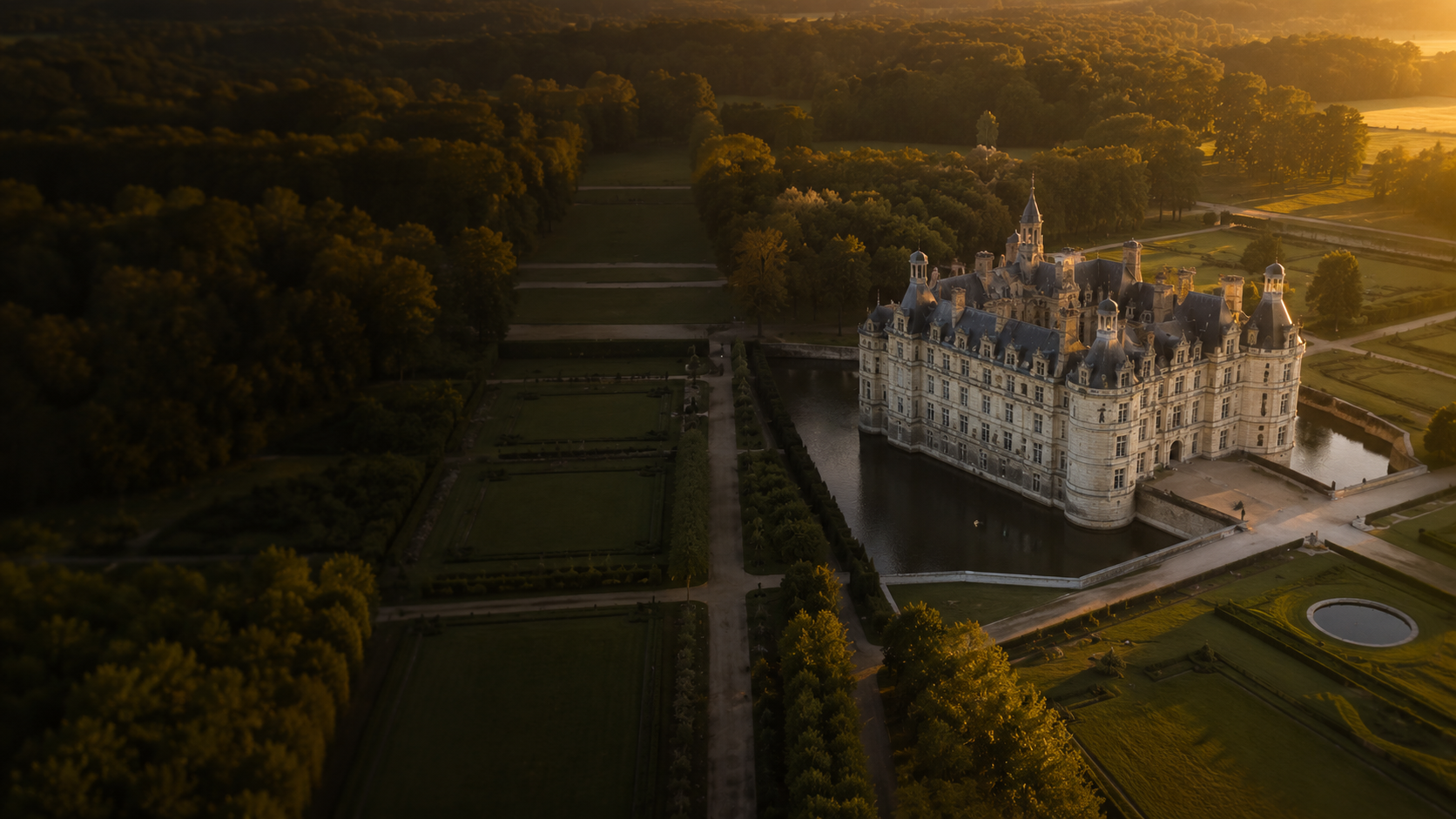 Vue aérienne d'un grand domaine et de ses jardins à la française au coucher du soleil
